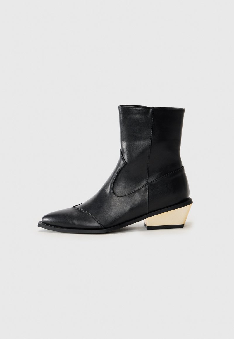 Botas de tobillo de cuero negro con punta afilada, que presentan un exclusivo tacón geométrico con acentos dorados y un acabado suave y elegante.