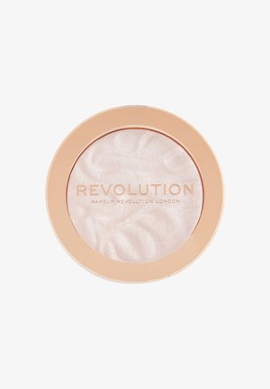 Enlumineur compact rond avec un couvercle couleur pêche et une poudre translucide embossée du texte "Revolution Makeup Revolution London".