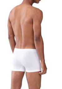 Vita boxershorts tillverkade av slät tyg, med en snug passform och en mjuk midja, med minimal design och inga synliga mönster.