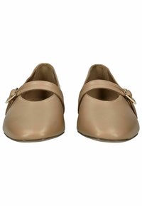 Zapatos planos beige con punta redondeada y una sola tira en el empeine, que presenta una pequeña hebilla metálica como acento. Textura suave.