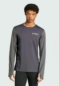 Dugih rukava sivi sportski majica od tkanine koja odvodi vlagu, s okruglim izrezom i suptilnim TERREX logotipom na prsima.