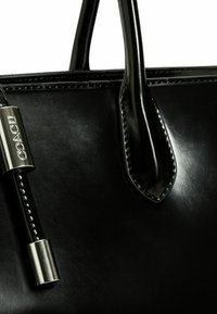 Borsa a mano in pelle nera con una texture liscia, caratterizzata da una finitura lucida, due manici corti e un accento in metallo argentato.