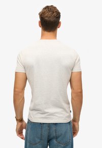Grå bomulds T-shirt med korte ærmer, tætsiddende design og rund halsudskæring. Glat tekstur, ingen mønstre eller synligt udstyr.