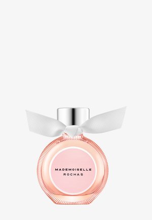 Flacon de parfum rond rose étiqueté « Mademoiselle Rochas » avec un bouchon argenté et un ruban blanc noué autour du col.