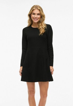 Schwarzes langärmliges Kleid, A-Linien-Schnitt, strukturierter Stoff, runder Ausschnitt, knielang, mit sauberen Nähten und einem minimalistischen Design.
