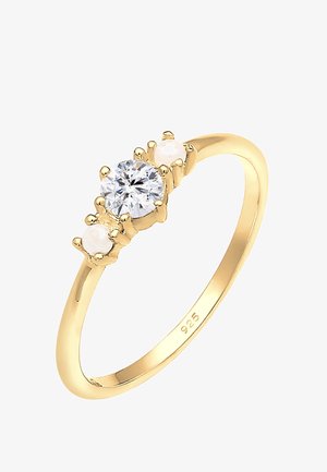 Goldbeschichteter Ring mit einem zentralen runden Kristall und zwei kleineren Perlen auf beiden Seiten. Schlichte Bandgestaltung mit polierter Metalloberfläche.