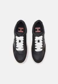 Czarne sneakersy ze skórzanym wierzchem, z białymi sznurowadłami, teksturowanym wierzchem i kontrastującą podeszwą, z logo marki z boku i wewnątrz.