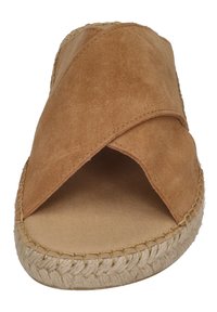 Brown suede slip-on sandal with a cross-over design, jute-wrapped sole, and a flat textured footbed. Open-toe style.