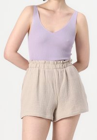 Débardeur côtelé lilas avec encolure en V et short beige texturé taille haute avec ceinture élastique. Conception lisse et ample.