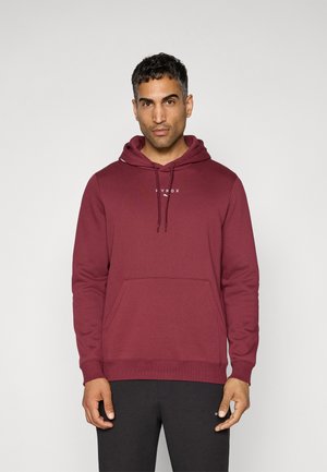 Maroonsweater med en frontlomme, snoretræk i huen og hvidt logo på brystet. Stoffet er blødt med en glat overflade.