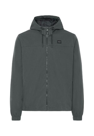 Szürke kapucnis dzseki, elöl cipzárral, rugalmas mandzsettákkal és oldalsó zsebekkel. Sima textúra és egyszerű, minimalista dizájn. Márkacímke a mellkasán.