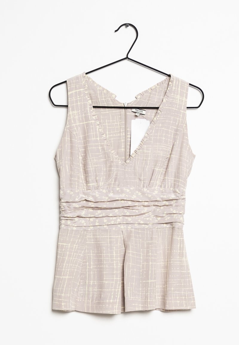 Ljusgrå ärmlös topp med V-ringning, med texturerade mönster och rynkad midjedetalj, hängande på en svart metallgalge.