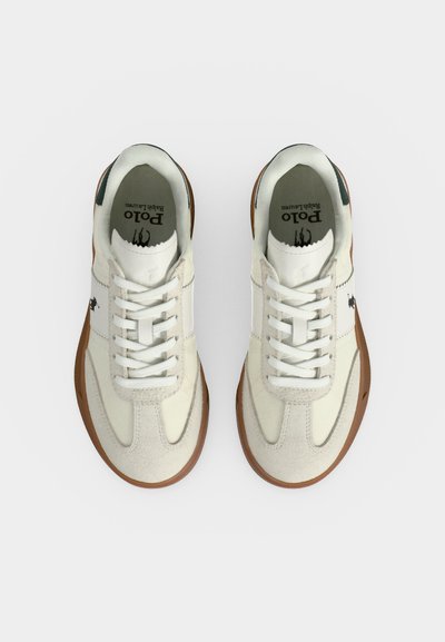 Ζευγάρι λευκά και ταμπά sneakers Polo Ralph Lauren με κορδόνια και λογότυπο στο πλάι και στην εσωτερική σόλα, εμφανιζόμενα από πάνω σε λευκό φόντο.