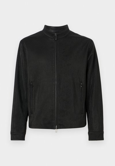 Schwarze Mesh-Jacke mit hohem Kragen, Frontreißverschluss und zwei seitlichen Reißverschluss-Taschen. Verfügt über ein strukturiertes Muster und eine lockere Passform.