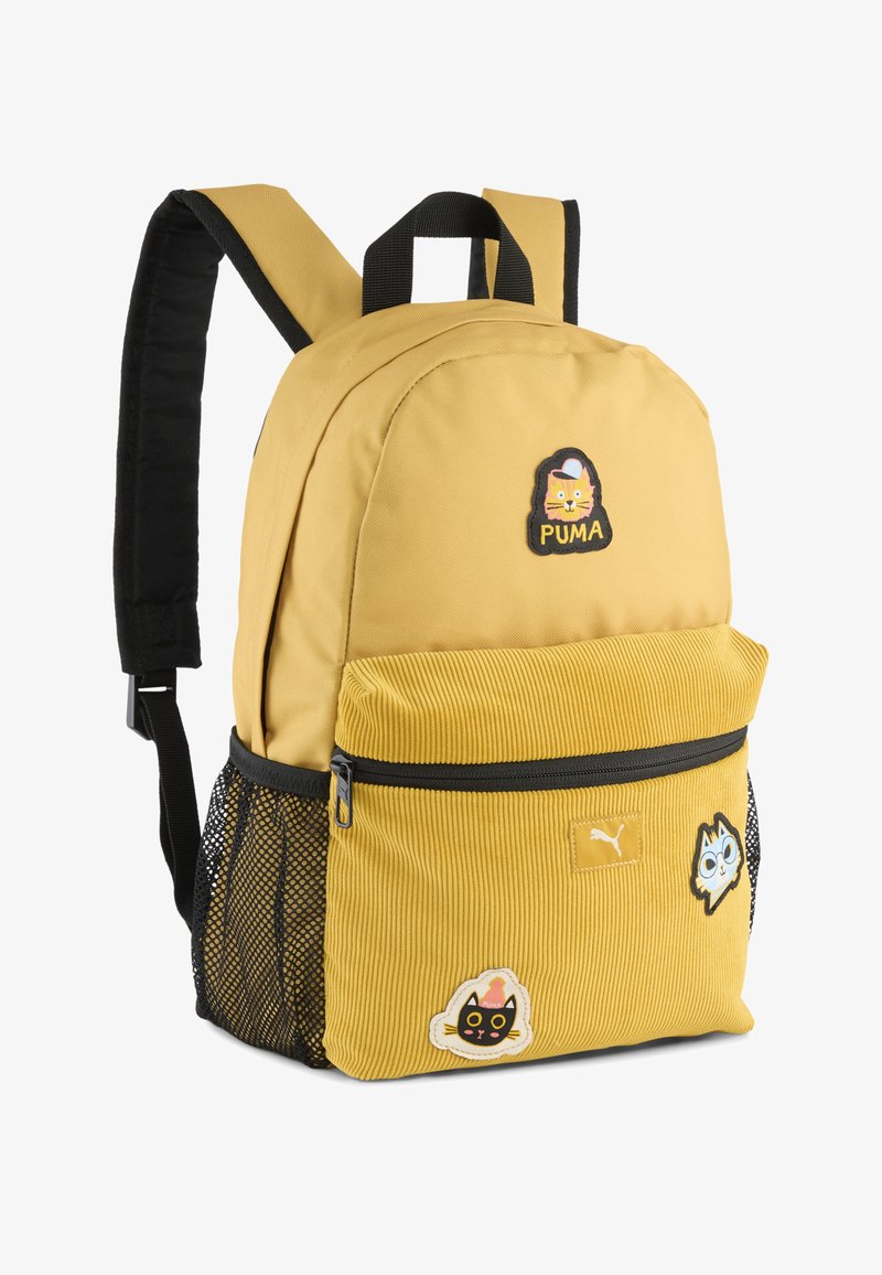 Mochila de tela amarilla con tirantes negros, que cuenta con un bolsillo delantero de pana, bolsillos laterales de malla y tres parches de personajes coloridos.