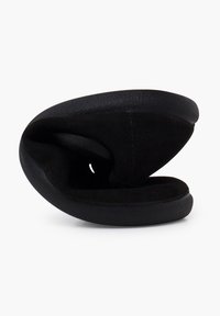 Zapatilla plegable negra con un diseño redondeado, fabricada en un suave tejido similar al ante y con una suela de goma texturizada. Ligera y flexible.