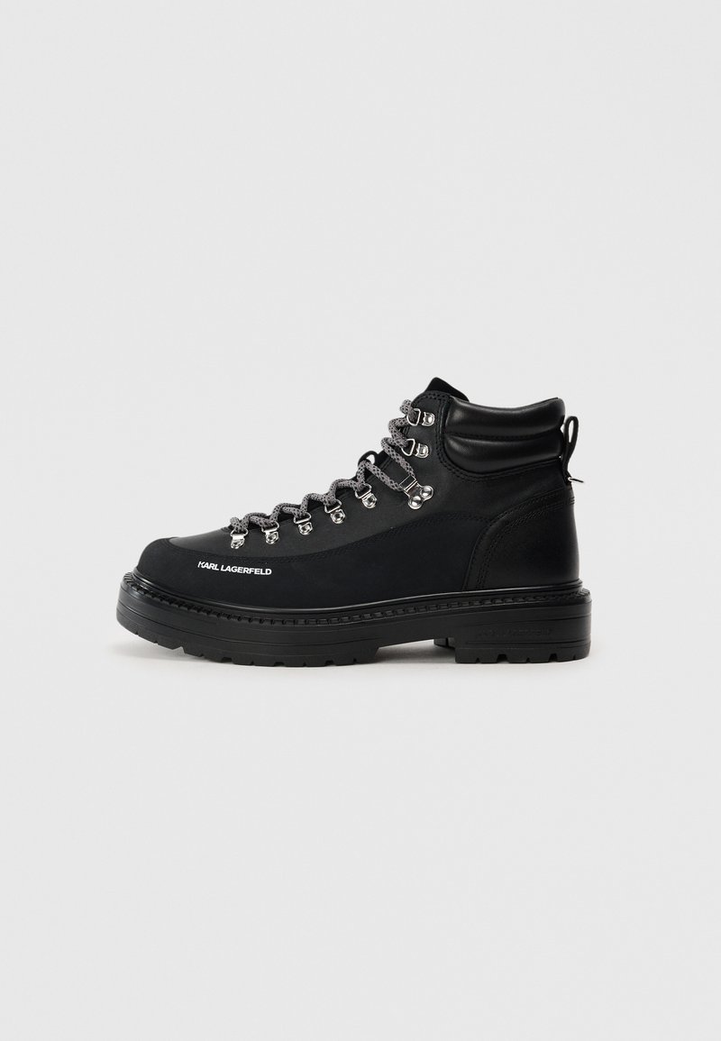 Botas de senderismo negras con parte superior de cuero texturizado, herrajes plateados y cordones grises. Presenta una suela robusta y un tobillo acolchado para mayor soporte.