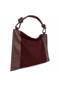 Sac fourre-tout bordeaux en suède et cuir, présentant un design décontracté, une anse nouée et une texture lisse avec des accents latéraux contrastés.