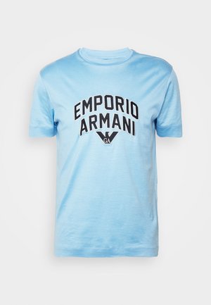Vaaleansininen puuvillapaita, jossa on pyöreä kaula-aukko. Etupuolella mustalla painettuna "EMPORIO ARMANI" -logo kaaren muotoisena. Lyhyet hihat.
