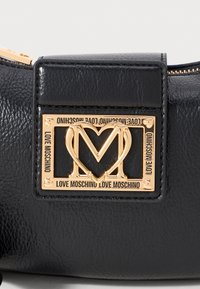 Black textured leather bag with gold rectangular Love Moschino logo featuring a heart-shaped "M" and text around the frame.