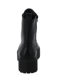 Botas negras de cuero hasta el tobillo con suela de goma texturizada y plana, cierre con cremallera en la parte posterior y un acabado liso.