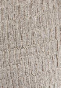 Textiel met een golvend patroon, in een lichte beige kleur, met een kreukelige uitstraling en een licht grove textuur.