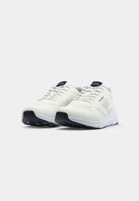 White knit athletic shoes with black soles and laces, featuring "Hilfiger" branding on the side and tongue, displayed on a white background.