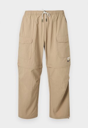 Μπεζ cargo παντελόνι τύπου convertible με ελαστική μέση, κορδόνι, δύο εμπρόσθιες τσέπες με καπάκι και φερμουάρ για προσαρμογή μήκους στα ποδία.