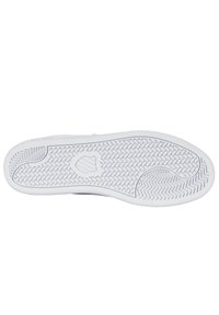 Semelle de chaussure en caoutchouc blanc avec une surface texturée présentant un motif en chevrons et un logo proéminent. Forme plate et design durable.