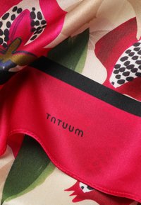 Rote und beige florale Schal mit schwarzen Punkten und grünen Blättern, mit einem schwarzen Streifen und dem Text "TANTUUM" im roten Bereich.