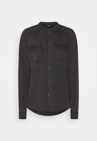 Zwarte spijkerblouse met lange mouwen, kraag, twee borstzakken, knoopsluiting aan de voorkant en een afgeronde onderkant. Zachte textuur met subtiele stikdetails.