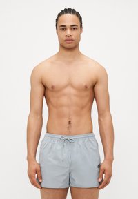 Grijze zwemshorts met een elastische tailleband en verstelbaar trekkoord. Glad materiaal met een lichte, snel drogende textuur.