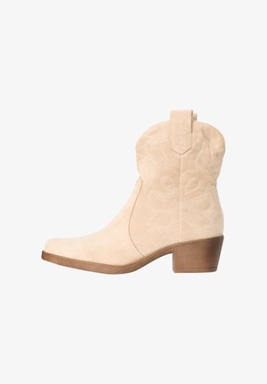 Beige suede ankle cowboy boot with embroidered details, pull tab, and medium brown stacked heel.