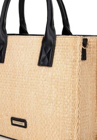 Borsa a tracolla in paglia intrecciata con manici in pelle nera, forma rettangolare e un dettaglio in metallo dorato con etichetta del marchio sul lato.