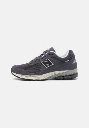 Grau sportlicher Schuh aus Mesh- und Wildledermaterial, mit runder Zehenpartie, Schnürdesign und einer gepolsterten Sohle mit Gummitraktions-Pads.