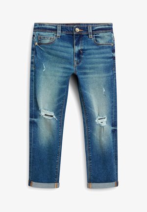 Jeans en denim bleu avec revers retroussés et déchirures usées sur les deux genoux, dotés de poches avant et arrière ainsi que de rivets en cuivre.