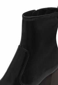Stivaletto nero con un esterno in pelle liscia, punta rotonda, cuciture laterali discrete e un tacco a blocco per un sostegno ottimale.