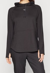 Svart atletisk hoodie med långa ärmar, texturerad tyg, framficka, justerbara snoddar och sidslitsar vid fållen.