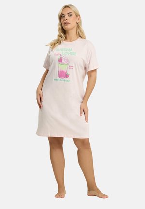 Mujer con vestido de manga corta color rosa claro, con una ilustración colorida de una bebida de matcha de fresa y el texto "MATCHA LOVER" en el frente.