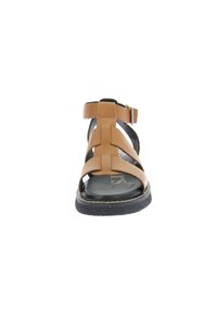 Sandal in pelle marrone con design open toe, cinturini incrociati, cinturino alla caviglia regolabile e suola nera testurizzata. Presenta un marchio sulla soletta.