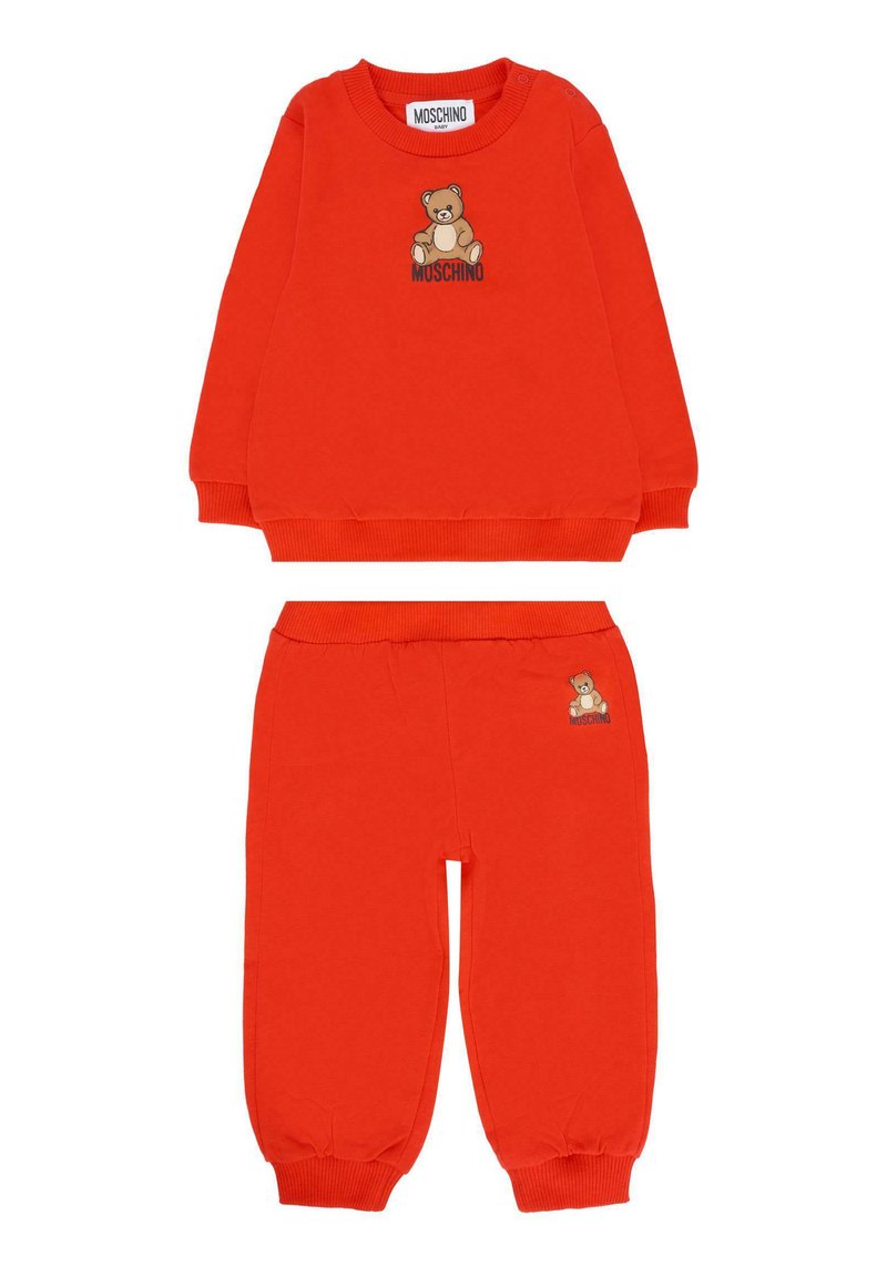 Felgroene babysweater en broekset met teddybeerafbeelding en "Moschino" tekst erboven en op de broek.