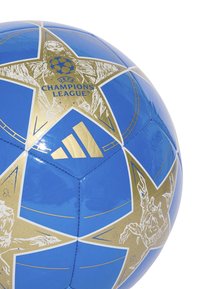 Modrý fotbalový míč se zlatými akcenty zobrazující logo Ligy mistrů UEFA a hvězdný vzor; vyrobený z lesklého, hladkého syntetického materiálu.