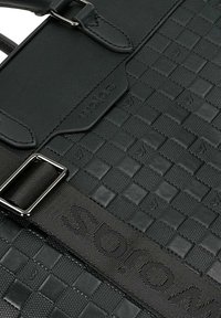 Borsa in pelle intrecciata nera con una texture liscia, dotata di una fibbia in metallo e di una tracolla brandizzata "Wolas."