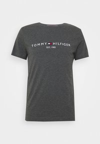 Camiseta de manga corta gris oscuro con "Tommy Hilfiger EST. 1985" y un pequeño logo de bandera roja, blanca y azul centrado en el pecho.
