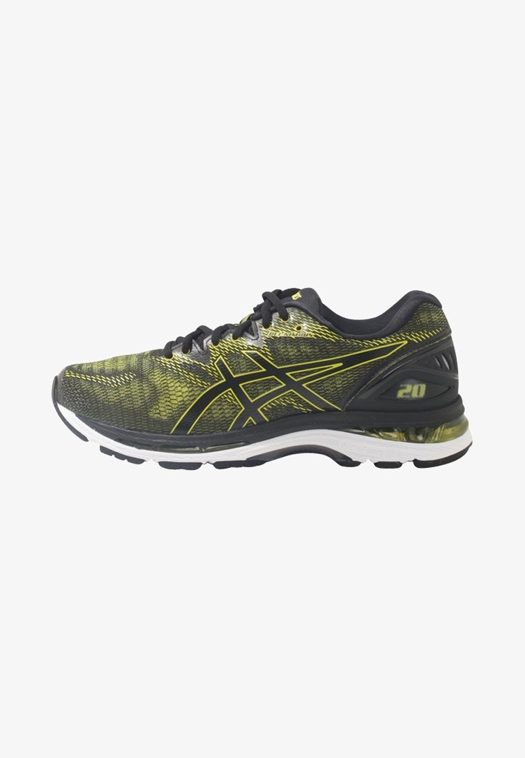Chaussure de course noire et jaune avec empeigne en mesh, lacets noirs, semelle blanche et talon rembourré marqué de "20" sur le côté.