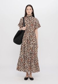 Maxikjole med leopardprint og korte ermer, med høy krage, samlet midje, lagdelt skjørt, og en svart flettet totebag.