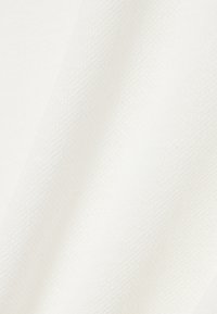 Tela blanca texturizada con finas rayas diagonales que crean un patrón sutil y pliegues suaves.
