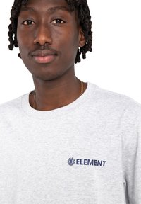 Szary krótki rękaw sweatshirt z granatowym logo "ELEMENT" na lewej piersi. Wykonany z miękkiej, teksturowanej mieszanki bawełny.
