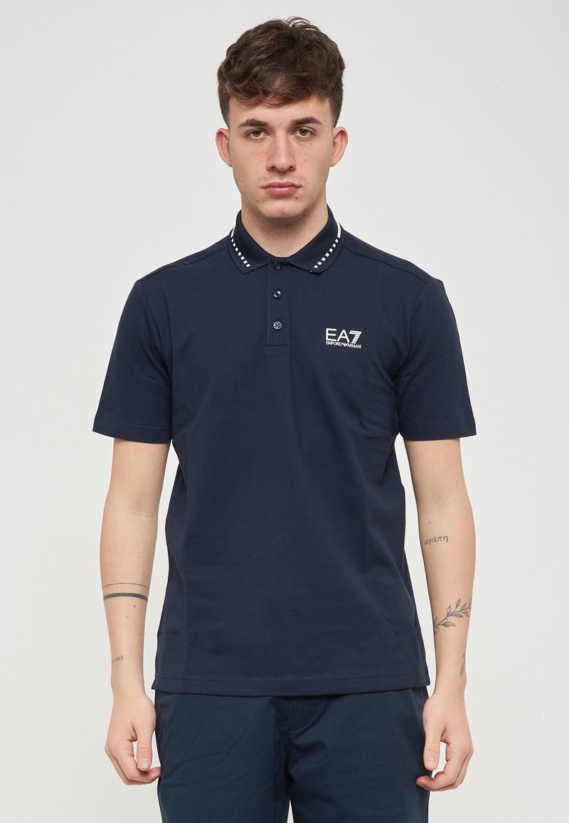 Polo shirt navy in cotone, con placket a tre bottoni, colletto decorativo con accenti bianchi e logo sul lato sinistro.