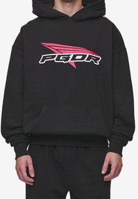 Černá mikina s kapucí s klokaní kapsou na přední straně, žebrovanými manžetami a velkým grafickým logem v bílé a růžové barvě. Měkký materiál, volný střih.